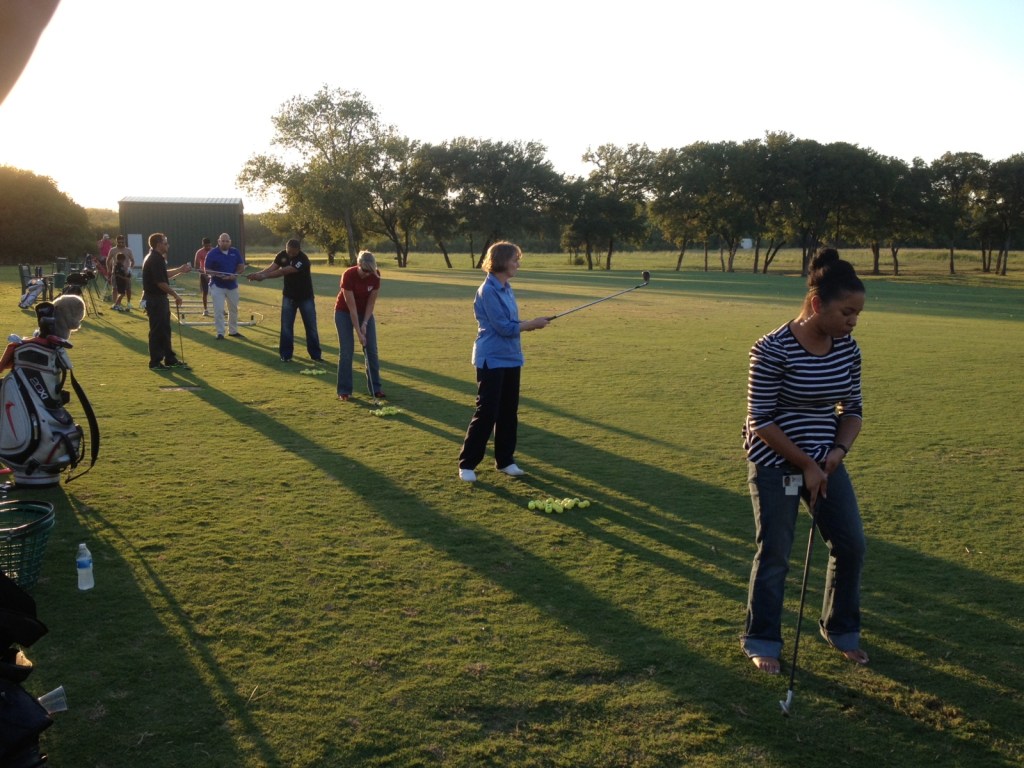 students practicing at the driving range